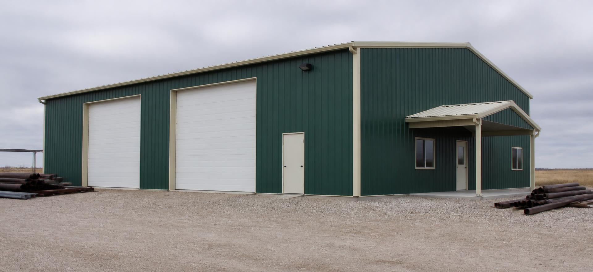Concept photograph of a green rigid-frame steel shop with cream trim, two overhead doors and a covered office entry on a gravel yard; example configuration, not a real project.