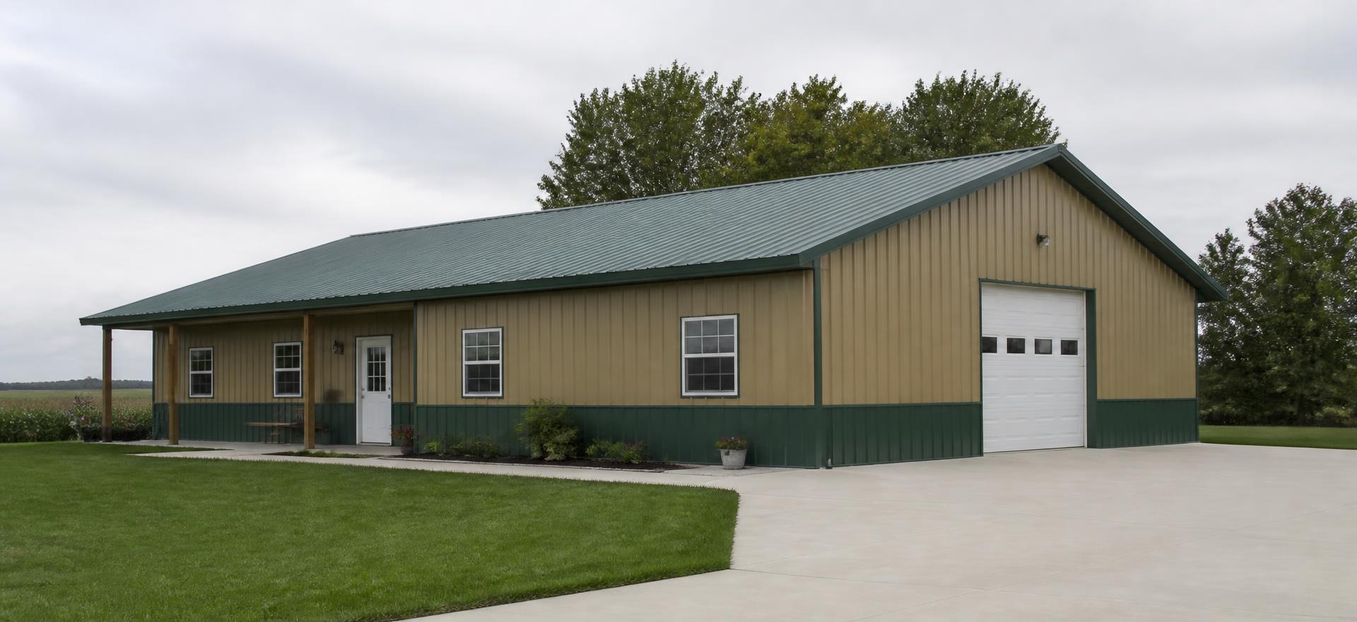 Concept photograph of a tan post-frame barndominium clad in steel with a green roof, covered porch, house windows and one overhead shop door; example configuration, not a real project.
