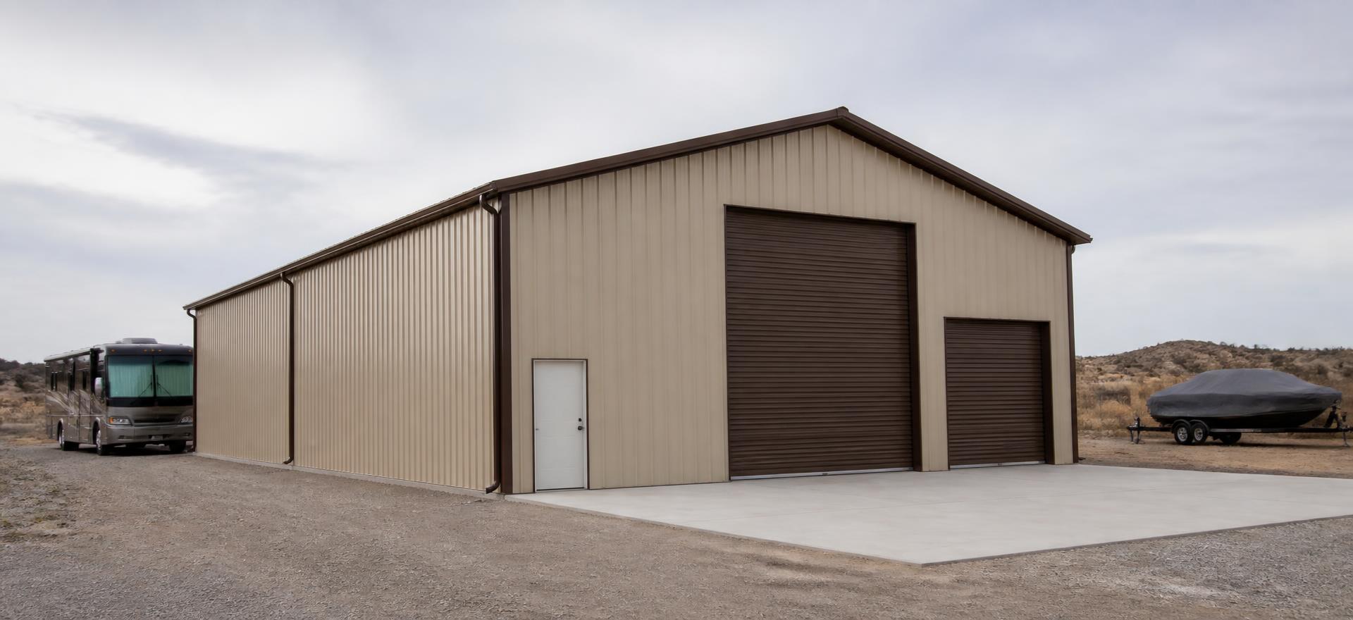 Concept photograph of a 40 by 60 foot tall tan steel RV storage building with a 16 foot roll-up door, a motorhome and a covered boat parked outside; example configuration, not a real project.
