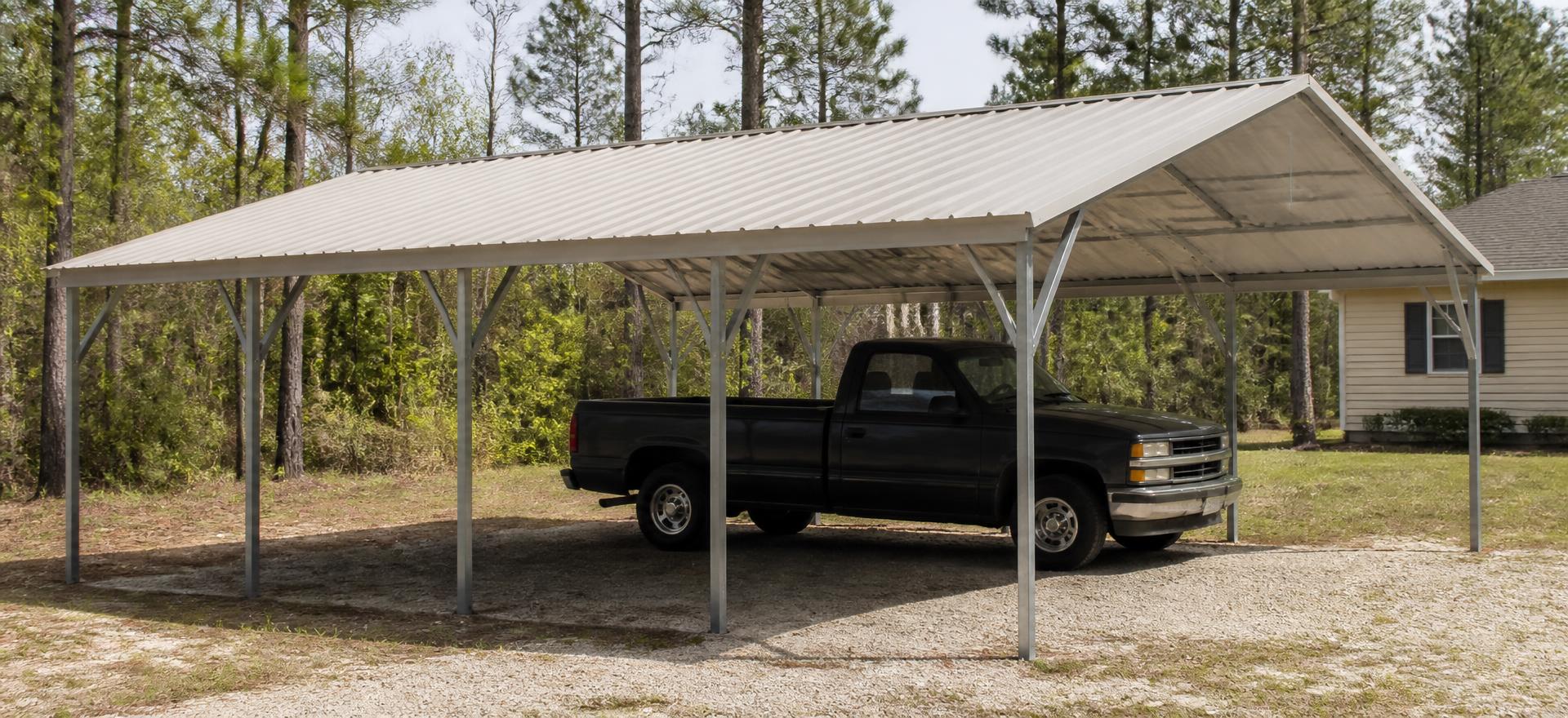 Concept photograph of a 20 by 26 foot open galvanized tube-frame carport with an A-frame metal roof over a gravel parking area beside a single-storey house; illustrative configuration, not a real project.