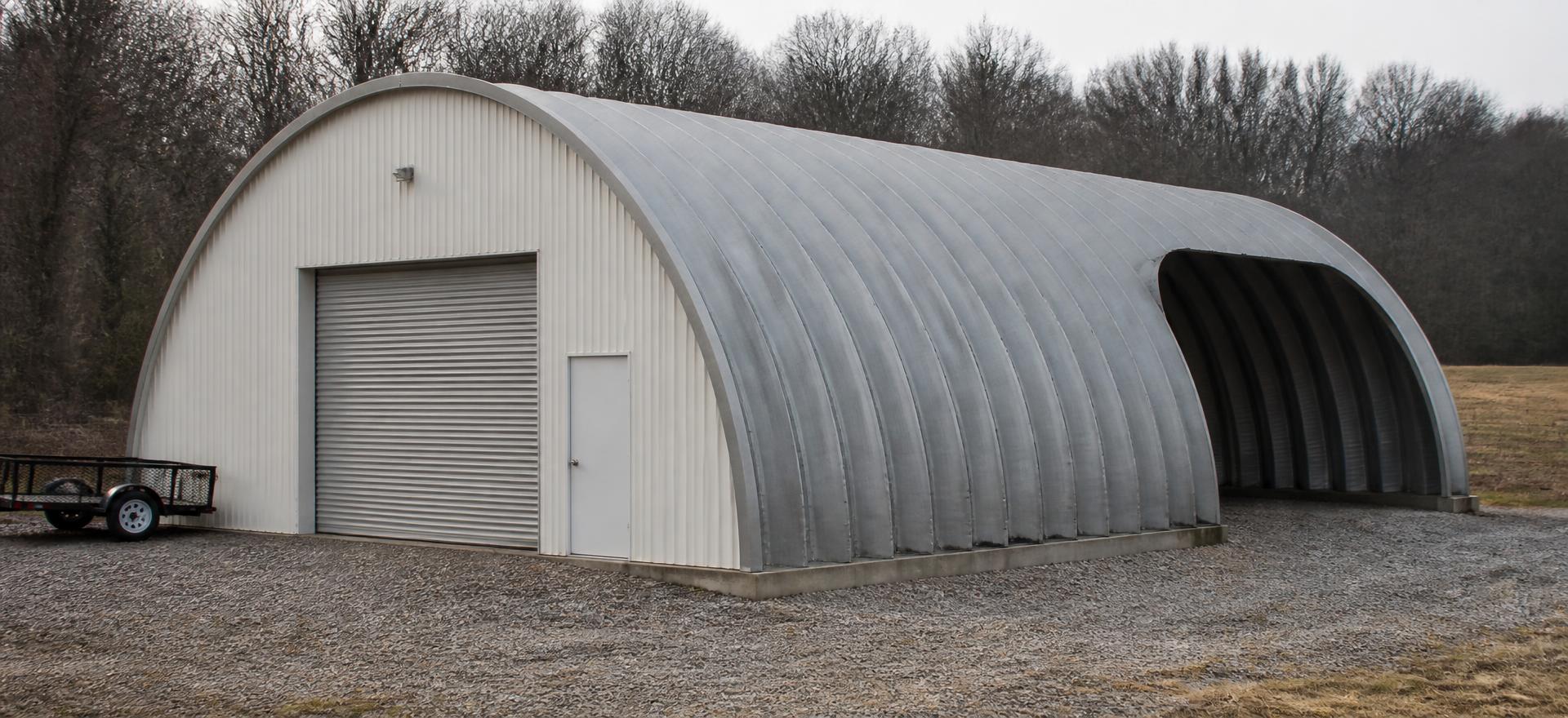 Concept photograph of a 40 by 60 foot galvanized corrugated steel arch building with a framed end wall, roll-up door and open far end on a gravel pad; example configuration, not a real project.